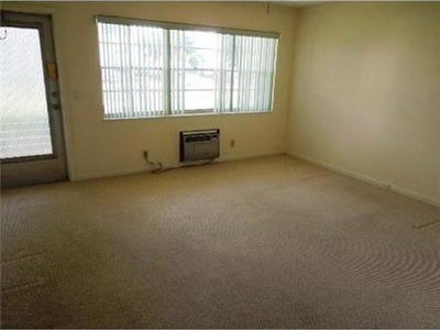 4 Northampton A 4, West Palm Beach, FL 33417 - spare room featuring a wall unit AC, plenty of natural light, and carpet flooring