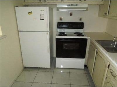 4 Northampton A 4, West Palm Beach, FL 33417 - kitchen with freestanding refrigerator, electric stove, extractor fan, a sink, and light tile patterned flooring