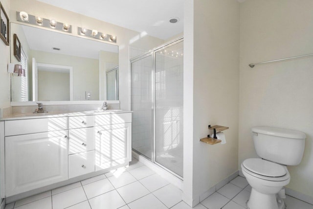 bathroom with a shower with door, vanity, tile patterned floors, and toilet