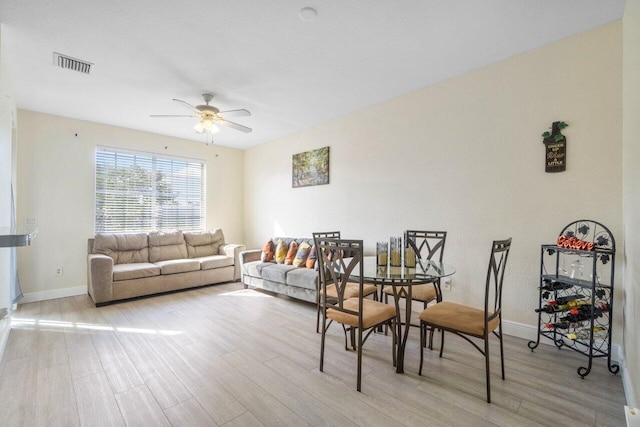 dining area with ceiling fan and light hardwood / wood-style flooring