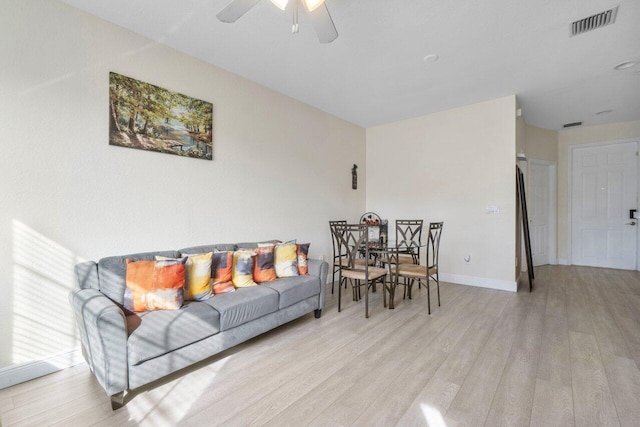 living room featuring ceiling fan and light hardwood / wood-style flooring