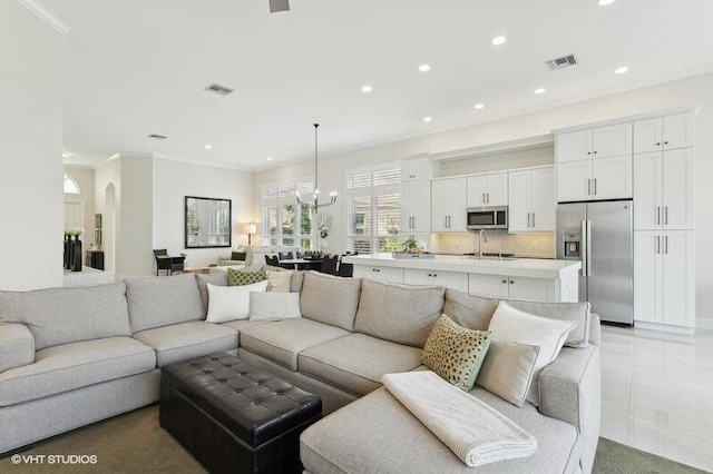 living room with a notable chandelier and crown molding