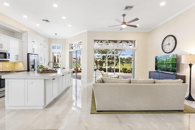 living room with ceiling fan and ornamental molding