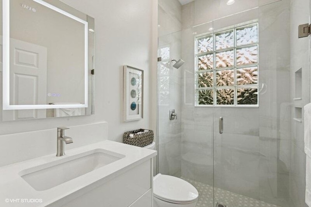 bathroom featuring vanity, toilet, and an enclosed shower