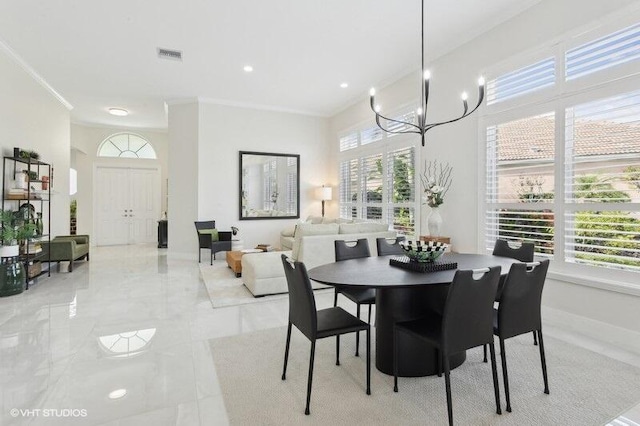 dining room with crown molding and a chandelier