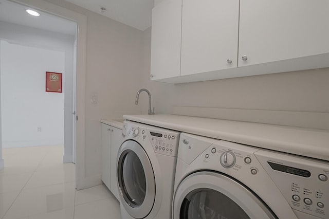 washroom featuring light tile patterned floors, sink, cabinets, and washing machine and clothes dryer