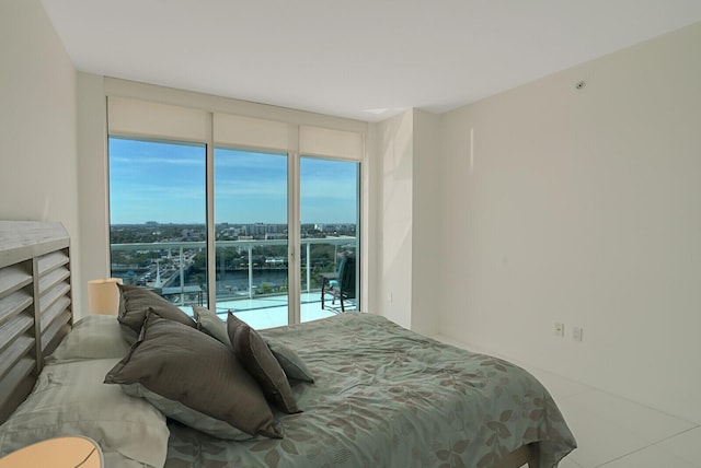 bedroom featuring a water view and floor to ceiling windows