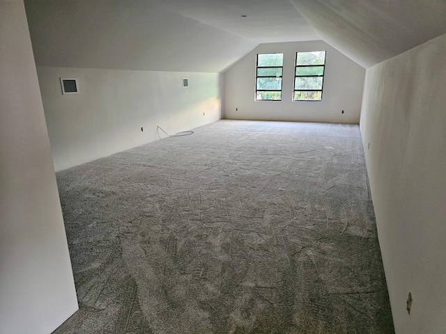 bonus room with vaulted ceiling and carpet