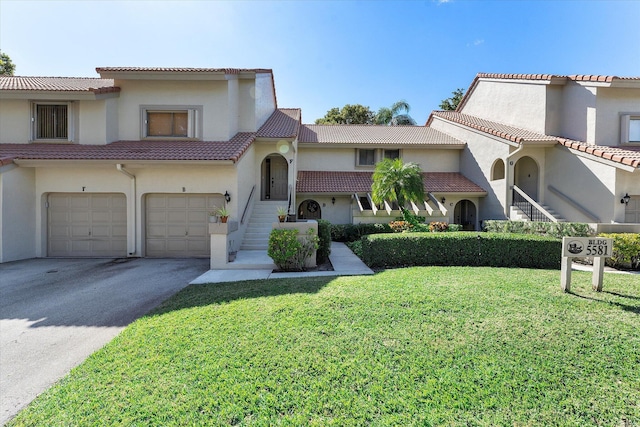 mediterranean / spanish house featuring a garage and a front lawn