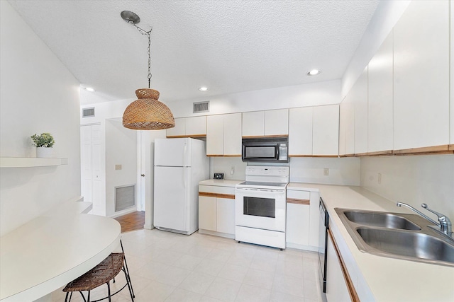 kitchen with pendant lighting, sink, white appliances, white cabinetry, and a textured ceiling