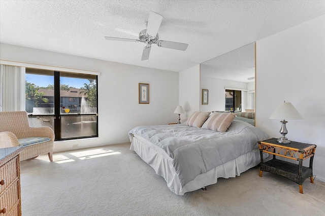 carpeted bedroom with ceiling fan and a textured ceiling