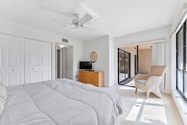 carpeted bedroom featuring ceiling fan, access to exterior, a closet, and a textured ceiling