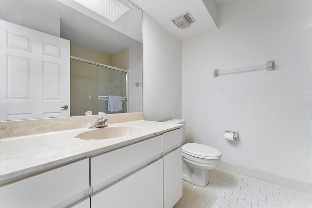 bathroom featuring tile patterned flooring, vanity, toilet, and a shower with shower door