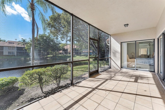 unfurnished sunroom featuring a water view