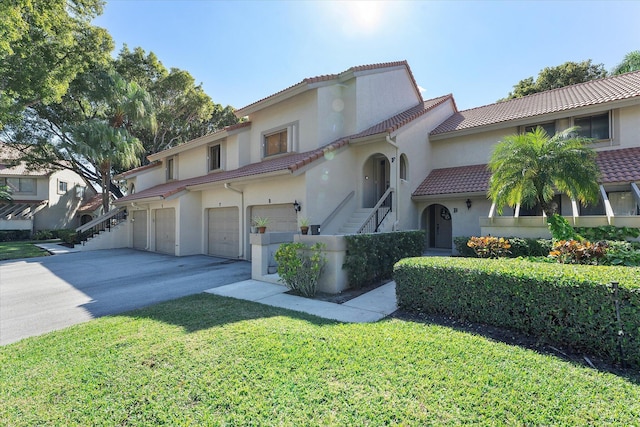 mediterranean / spanish house with a garage and a front yard