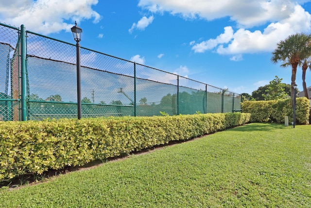 view of tennis court with a lawn