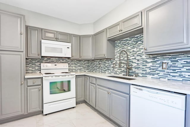 kitchen featuring gray cabinets, sink, white appliances, and decorative backsplash