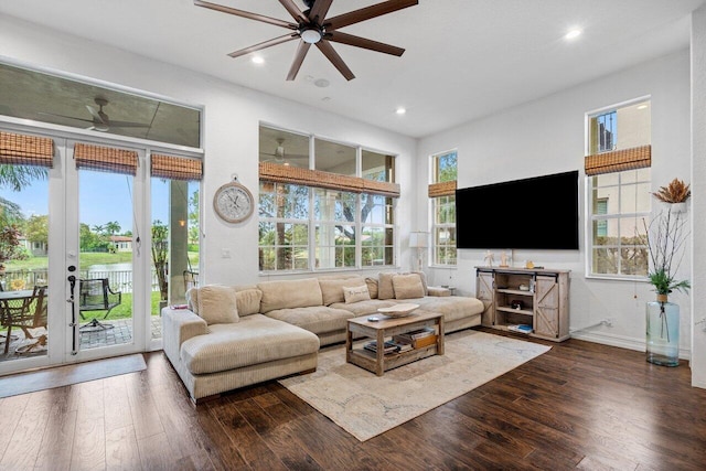 living room featuring ceiling fan, dark wood-type flooring, and a wealth of natural light