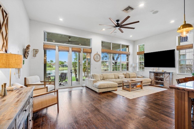 living room featuring ceiling fan, dark wood-type flooring, french doors, and a healthy amount of sunlight