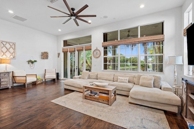 living room featuring dark wood-type flooring and ceiling fan