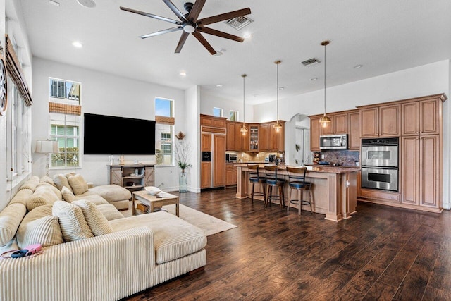 living room featuring dark wood-type flooring and ceiling fan