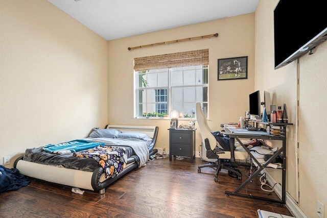 bedroom with dark hardwood / wood-style flooring