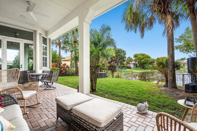 view of patio / terrace with ceiling fan and a water view