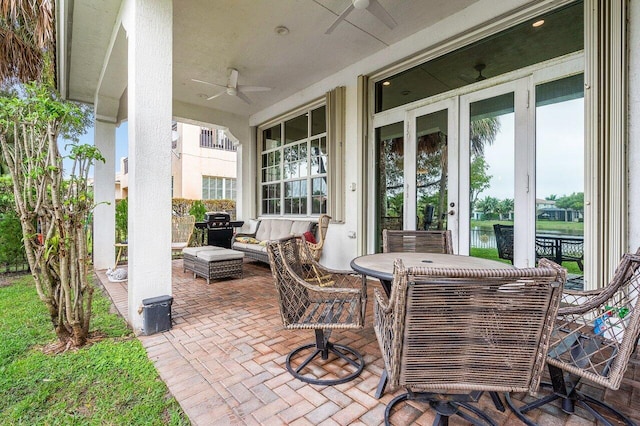 view of patio / terrace featuring ceiling fan, a water view, and area for grilling