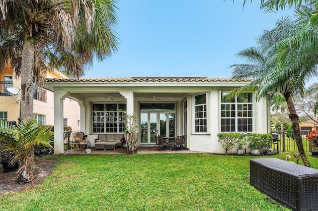 back of house featuring an outdoor living space, a lawn, and a patio