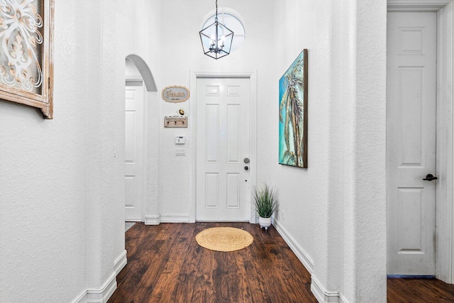 entrance foyer featuring dark wood-type flooring and a chandelier