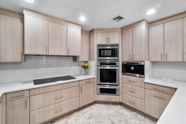 kitchen featuring light brown cabinetry and appliances with stainless steel finishes