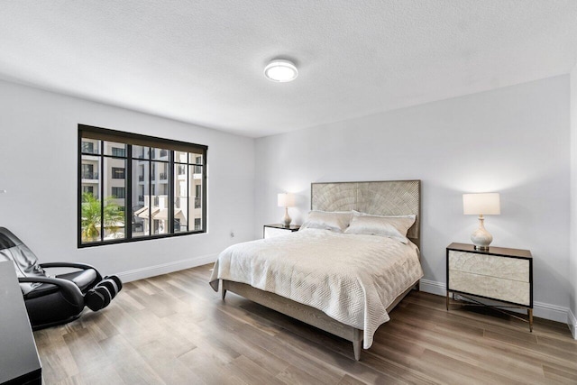 bedroom featuring hardwood / wood-style flooring and a textured ceiling