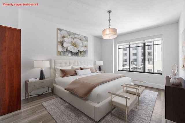 bedroom with hardwood / wood-style floors and a textured ceiling