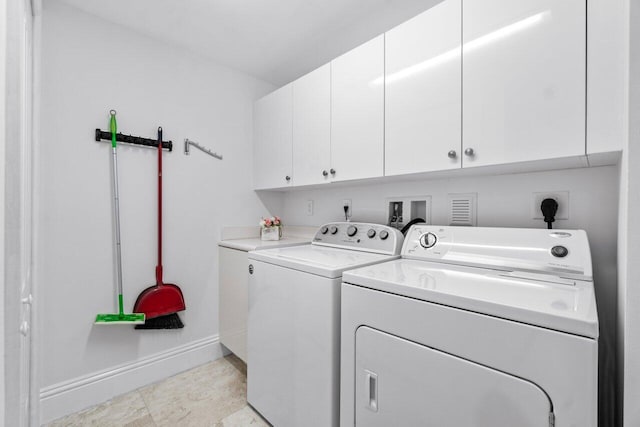 clothes washing area with independent washer and dryer and cabinets