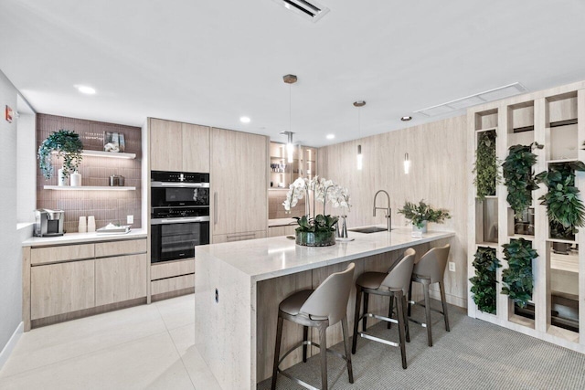 kitchen featuring sink, hanging light fixtures, backsplash, double wall oven, and light stone countertops