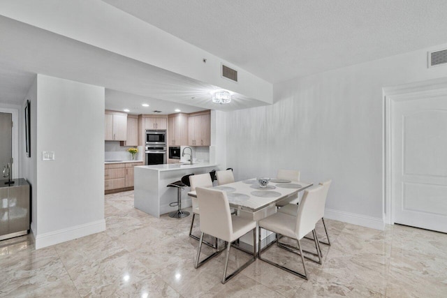 dining area featuring sink and a textured ceiling