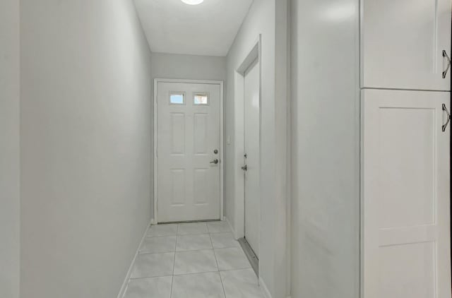 doorway to outside with light tile patterned flooring