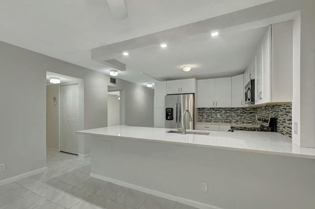 kitchen featuring appliances with stainless steel finishes, kitchen peninsula, sink, and white cabinets