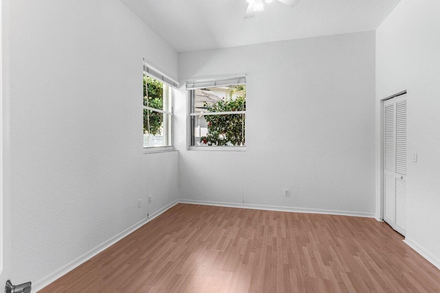 unfurnished bedroom featuring light hardwood / wood-style flooring, a closet, and ceiling fan