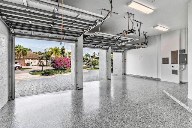 garage with a garage door opener and electric panel