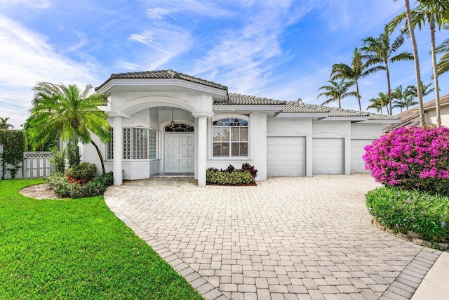 mediterranean / spanish-style house featuring a garage and a front yard