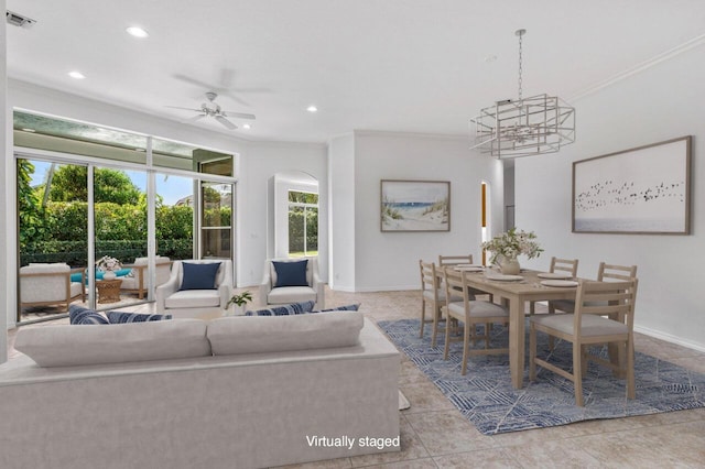 living room featuring light tile patterned floors, ceiling fan with notable chandelier, and ornamental molding