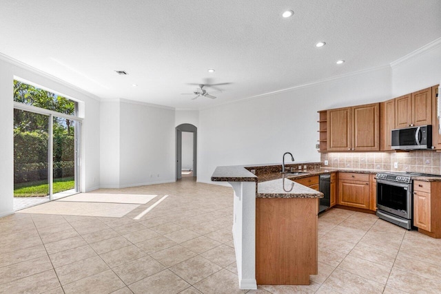 kitchen with ornamental molding, appliances with stainless steel finishes, dark stone countertops, and kitchen peninsula