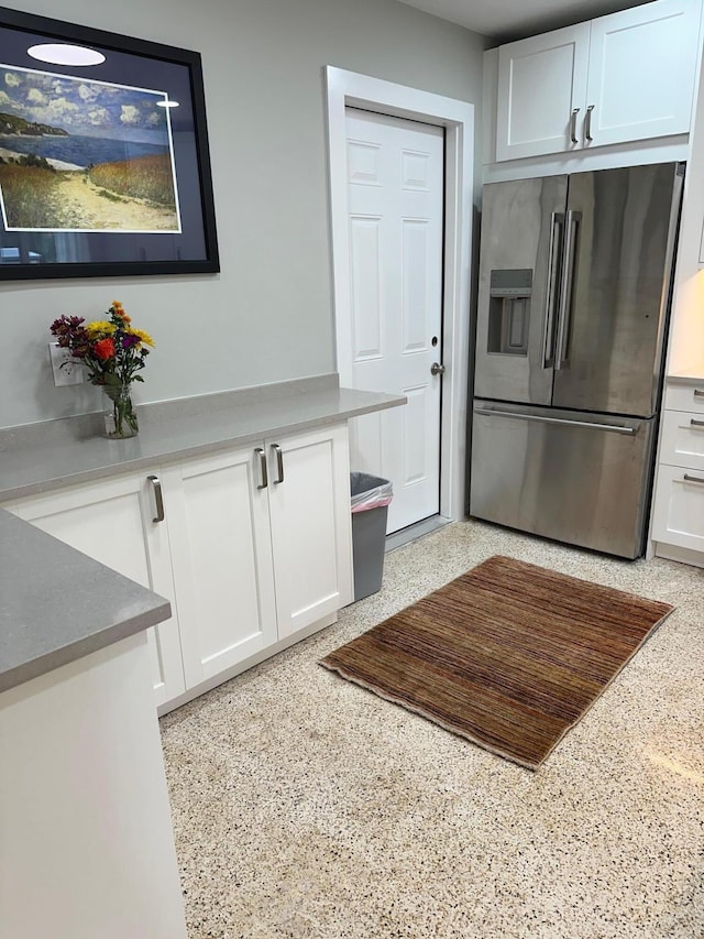 kitchen with white cabinets and stainless steel fridge with ice dispenser