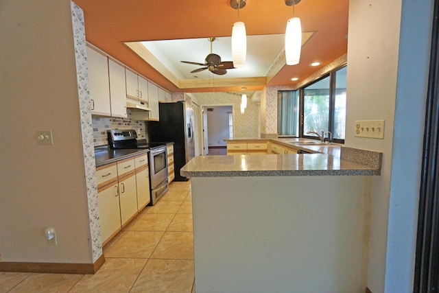 kitchen featuring sink, stainless steel appliances, a tray ceiling, white cabinets, and kitchen peninsula