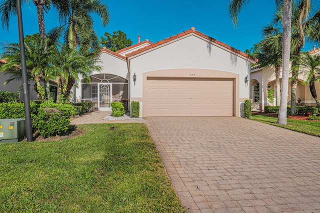 mediterranean / spanish home with a garage and a front yard