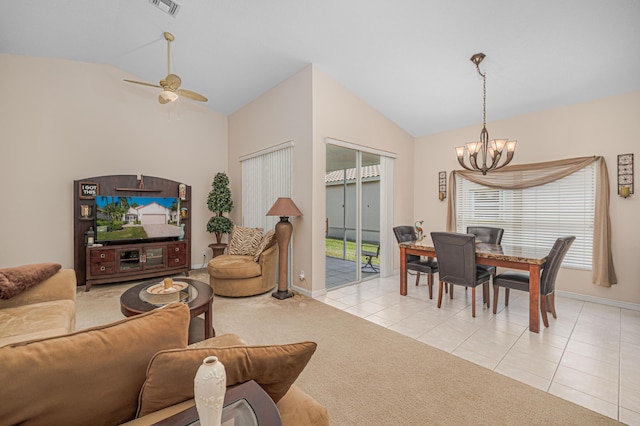 living room featuring ceiling fan with notable chandelier, vaulted ceiling, and light tile patterned floors