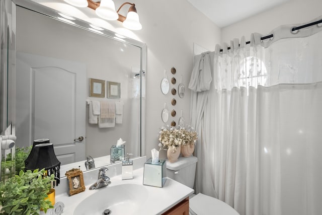 bathroom with toilet, vanity, and walk in shower