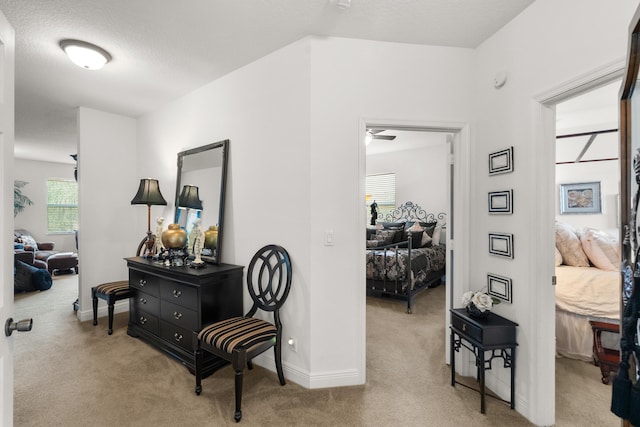 hall with a textured ceiling and light carpet