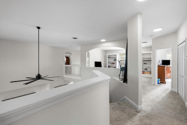 hallway featuring light colored carpet